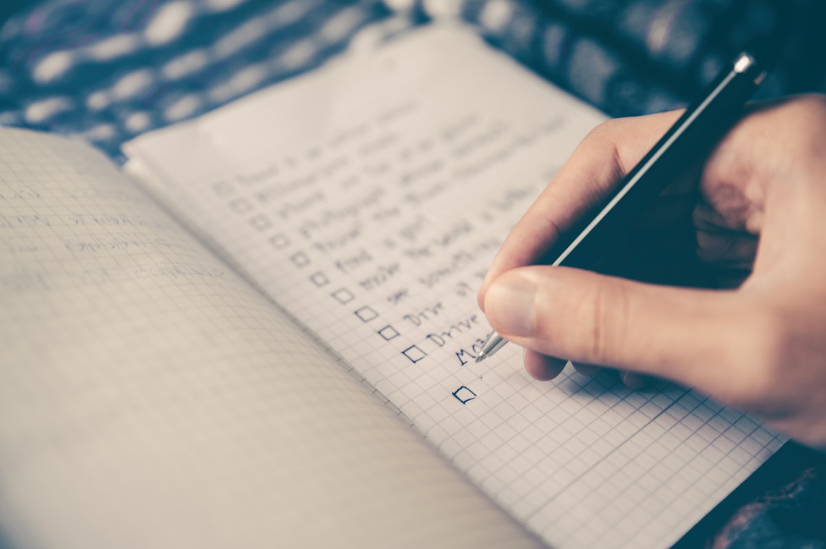 Open notebook and pen for farm planning outdoors with handwritten goals and lists - how to start homesteading